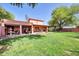 A spacious backyard with lush grass, trees, and a covered patio perfect for outdoor relaxation and entertaining at 17705 E Canyon Way, Gilbert, AZ 85298
