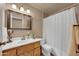 Bathroom with wood cabinets, large mirror, and tiled shower at 17705 E Canyon Way, Gilbert, AZ 85298