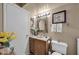 Bright bathroom with a wood vanity, ornate mirror, and tiled flooring at 17705 E Canyon Way, Gilbert, AZ 85298