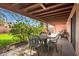 Inviting covered patio with an outdoor dining area, lush foliage, and backyard views at 17705 E Canyon Way, Gilbert, AZ 85298