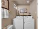 Bright laundry room featuring white washer and dryer and open shelf with decorations at 17705 E Canyon Way, Gilbert, AZ 85298
