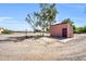 Exterior view of a small outbuilding with surrounding dirt, trees, and a horse paddock at 17705 E Canyon Way, Gilbert, AZ 85298