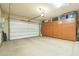 Spacious garage with ample storage cabinets, providing organized space for vehicles and equipment with epoxy flooring at 1805 W Dusty Wren Dr, Phoenix, AZ 85085