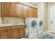 Functional laundry room with washer, dryer, sink, and storage cabinets at 1805 W Dusty Wren Dr, Phoenix, AZ 85085