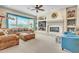 Bright living room with a fireplace, custom built-ins, a ceiling fan, and large windows at 1805 W Dusty Wren Dr, Phoenix, AZ 85085