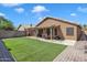 Backyard with covered patio, synthetic grass, and brick border at 18845 N 23Rd Pl, Phoenix, AZ 85024