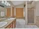 Bright bathroom featuring double sinks, granite countertops, a soaking tub, and a separate glass-enclosed shower at 18845 N 23Rd Pl, Phoenix, AZ 85024