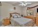 Comfortable bedroom featuring a queen bed with stylish bedding, ceiling fan, and wooden furniture at 18845 N 23Rd Pl, Phoenix, AZ 85024