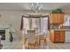 Open dining area with modern chandelier, large windows and view to the kitchen and living area at 18845 N 23Rd Pl, Phoenix, AZ 85024