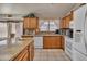 Well-equipped kitchen featuring a suite of white appliances, granite countertops, and classic wood cabinetry at 18845 N 23Rd Pl, Phoenix, AZ 85024