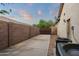 Enclosed backyard with tall brick walls, a gate, and an installed air conditioning unit at 19902 S 190Th St, Queen Creek, AZ 85142