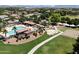 Aerial view of a community pool, splashpad, sand volleyball, park, and lush green spaces with mountain views in the distance at 19902 S 190Th St, Queen Creek, AZ 85142