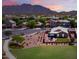 Expansive aerial view of a well-maintained community with mountain views and a lush green common area at 2070 E Saddlebrook Ct, Gilbert, AZ 85298