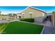 A backyard with synthetic grass, patio, and lush green hedges offering a private outdoor space at 2070 E Saddlebrook Ct, Gilbert, AZ 85298