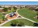 Aerial view of a community park, featuring a playground, green spaces, and walking paths at 2070 E Saddlebrook Ct, Gilbert, AZ 85298