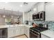 Bright kitchen features white cabinets, stainless steel appliances, and tiled backsplash at 2070 E Saddlebrook Ct, Gilbert, AZ 85298
