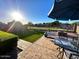 Backyard patio with outdoor seating, fire pit, grass, and sunny sky at 2070 E Saddlebrook Ct, Gilbert, AZ 85298