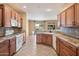 Well-lit kitchen featuring wooden cabinetry, tile backsplash, and stainless steel appliances at 20900 N Vista Trl, Surprise, AZ 85387