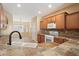 Cozy kitchen with wooden cabinets, tile backsplash, and a breakfast bar overlooking the dining area at 20900 N Vista Trl, Surprise, AZ 85387