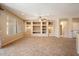 Spacious living room with tile flooring, built-in shelving and niches, and a ceiling fan at 20900 N Vista Trl, Surprise, AZ 85387