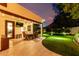 Backyard patio with dining, green lawn, a trampoline, mature trees, and privacy fence at 2139 S Granite St, Gilbert, AZ 85295