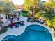Aerial view showcases a backyard with pool, outdoor bar, lounge chairs, fire pit, and trampoline at 2139 S Granite St, Gilbert, AZ 85295