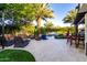 A backyard patio features travertine tile, outdoor furniture and a swimming pool in the background at 2139 S Granite St, Gilbert, AZ 85295