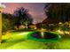Grassy backyard with an in-ground trampoline surrounded by mature trees and garden areas at 2139 S Granite St, Gilbert, AZ 85295