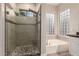Bathroom showcasing a glass shower, a soaking tub, and tiled walls at 2139 S Granite St, Gilbert, AZ 85295