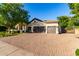 Exterior shot of this home featuring a spacious driveway, a three-car garage, and beautiful landscaping at 2139 S Granite St, Gilbert, AZ 85295