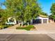 A beautifully landscaped home features mature trees, a driveway, and a three-car garage at 2139 S Granite St, Gilbert, AZ 85295