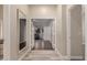 Hallway featuring tile floors and a doorway view to a living area with wood floors at 2139 S Granite St, Gilbert, AZ 85295