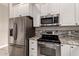 Modern kitchen with stainless steel appliances, granite countertops, and custom backsplash at 2139 S Granite St, Gilbert, AZ 85295