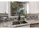 Well-lit kitchen features granite countertops, stainless steel sink, modern faucet, and backyard view at 2139 S Granite St, Gilbert, AZ 85295
