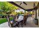 Covered patio featuring outdoor dining, lush landscaping, and a glimpse of the backyard pool, ideal for relaxation and entertainment at 2139 S Granite St, Gilbert, AZ 85295