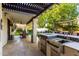 Outdoor kitchen with sink, grill, and bar area, next to outdoor dining under a covered patio for luxury backyard living at 2139 S Granite St, Gilbert, AZ 85295