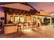 Enjoy this backyard's outdoor kitchen with bar seating and built-in grill under a wooden pergola at 2139 S Granite St, Gilbert, AZ 85295