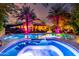 Inviting backyard pool with water features, patio seating, and colorful nighttime lighting at 2139 S Granite St, Gilbert, AZ 85295