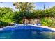 Inviting pool featuring a waterfall spa with colorful mosaic tiles and lush landscaping for backyard tranquility at 2139 S Granite St, Gilbert, AZ 85295
