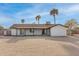 Rear exterior of a single-story home with a covered patio, palm trees, and a large backyard at 22312 W Hammond Dr, Buckeye, AZ 85326