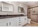 Bathroom with dual sinks, granite countertop, and shower with glass door, showcasing modern fixtures and tile at 22312 W Hammond Dr, Buckeye, AZ 85326