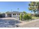 Single-story home with a modern garage door, patio sitting area, and desert landscaping at 3029 E Elm St, Phoenix, AZ 85016