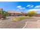 A beautifully landscaped backyard featuring a green lawn, decorative gravel, and a covered patio at 30587 N Maple Chase Dr, San Tan Valley, AZ 85143