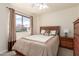 Cozy bedroom with a large window, neutral-toned bedding, and a view of the outdoors at 30587 N Maple Chase Dr, San Tan Valley, AZ 85143