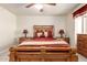 Comfortable bedroom featuring a wooden bed frame, ceiling fan, and red accents at 30587 N Maple Chase Dr, San Tan Valley, AZ 85143