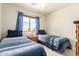 Bright bedroom with two twin beds, blue curtains, and carpeted flooring at 30587 N Maple Chase Dr, San Tan Valley, AZ 85143