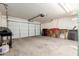 Spacious garage featuring a large overhead door, ample storage space, and a workbench area at 30587 N Maple Chase Dr, San Tan Valley, AZ 85143