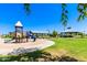 Community playground featuring slides and play structures, surrounded by green grass and landscaping, with shaded picnic areas at 30587 N Maple Chase Dr, San Tan Valley, AZ 85143