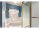 Stylish bathroom showcasing blue wallpaper, glass shower door, and tiled corner bathtub at 3131 E Las Rocas Dr, Phoenix, AZ 85028