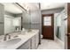 Bathroom with a dual sink vanity, shower and access to backyard at 3131 E Las Rocas Dr, Phoenix, AZ 85028